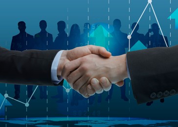 Image of Business partners shaking hands against silhouettes of people
