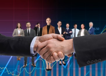 Image of Partners shaking hands against group of business people
