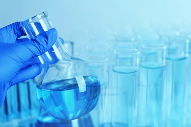 Image of Laboratory analysis. Scientist holding flask, double exposure with test tubes