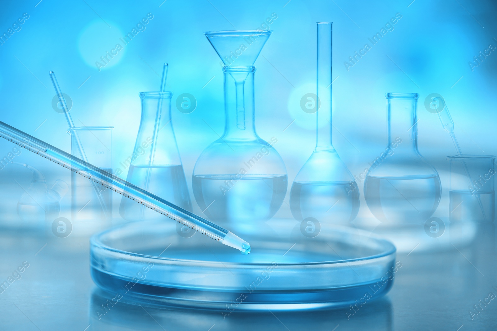 Image of Laboratory analysis. Dripping reagent into Petri dish, double exposure with glassware