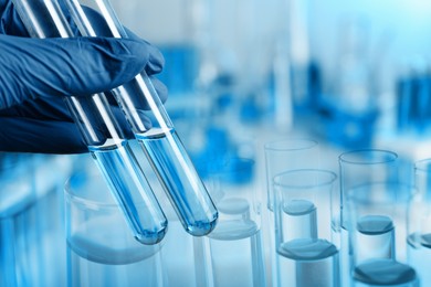 Image of Laboratory analysis. Scientist holding test tubes, double exposure with glassware