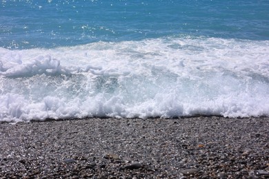 Photo of Beautiful view of wavy sea and pebbles on beach