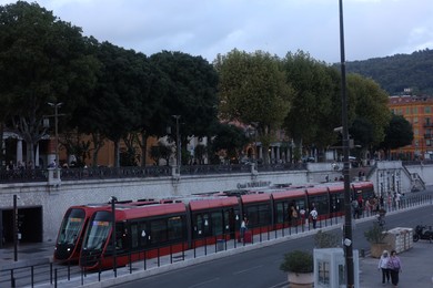 Photo of Nice, France - August 24, 2025: Picturesque view of tram, buildings and trees in city