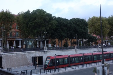 Photo of Nice, France - August 24, 2025: Picturesque view of tram, buildings and trees in city