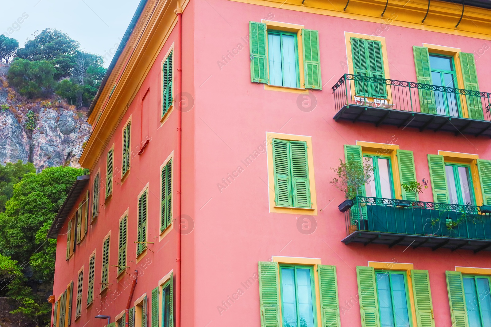 Photo of Beautiful building with windows and balconies against blue sky in city, low angle view