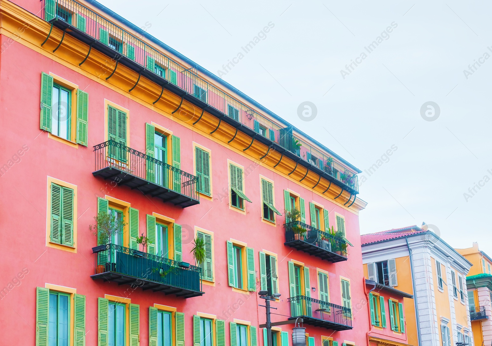 Photo of Beautiful buildings with windows and balconies against blue sky in city, low angle view