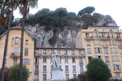 Photo of Nice, France - August 24, 2025: Beautiful building with windows and trees in city, low angle view