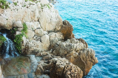 Photo of Beautiful view of clean water and stones on shore at summer