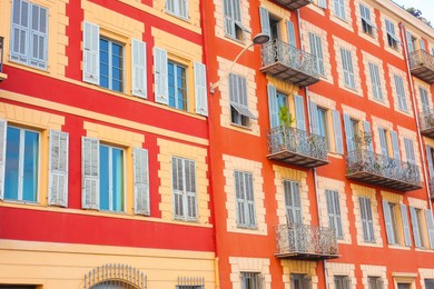 Photo of Beautiful building with windows and balconies in city, low angle view