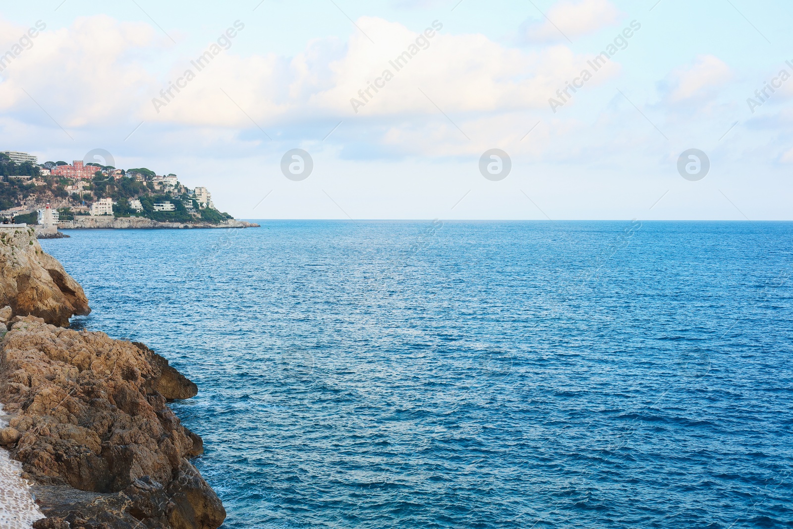 Photo of Picturesque view of sea, city and cliff under blue sky