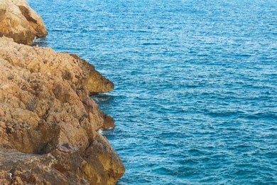 Photo of Picturesque view of cliff near wavy sea