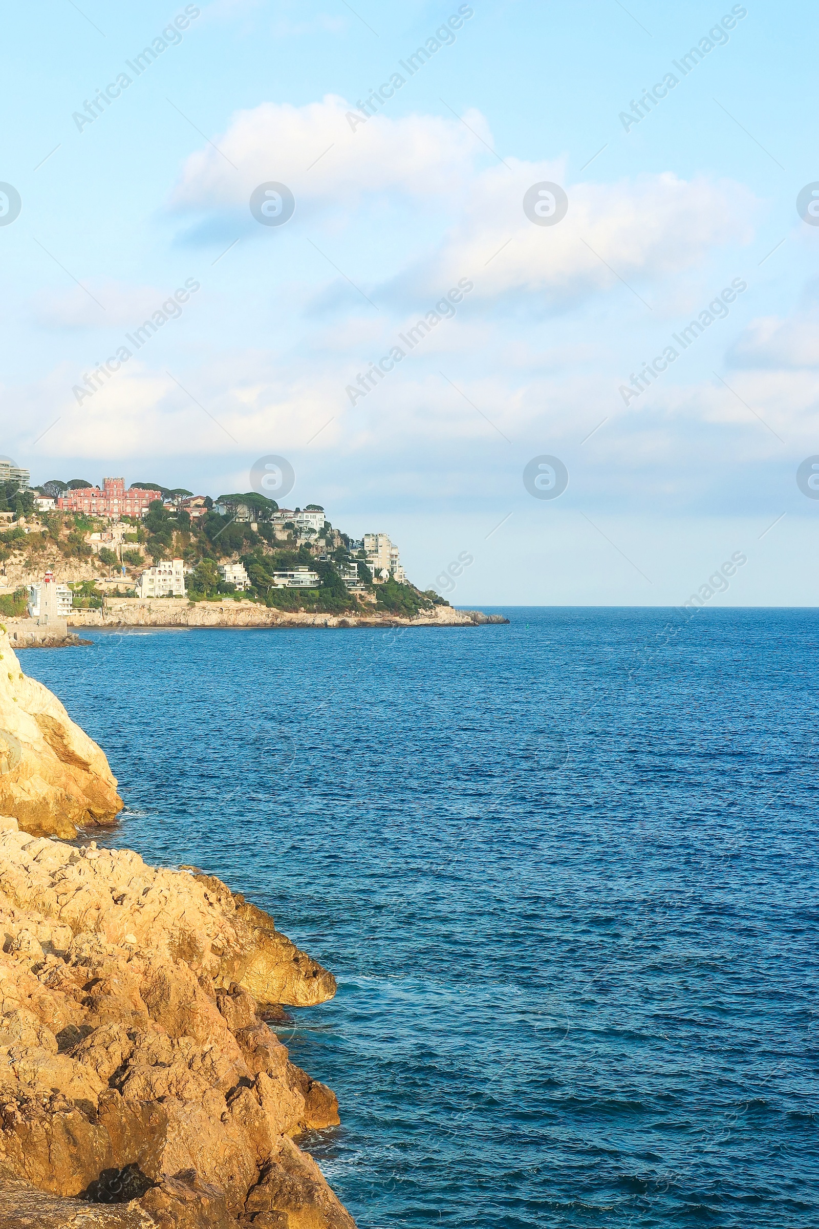 Photo of Picturesque view of sea, city and cliff under blue sky
