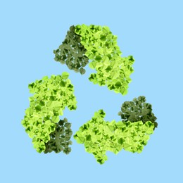 Image of Recycle sign. Chasing arrows with pattern of green leaves on light blue background