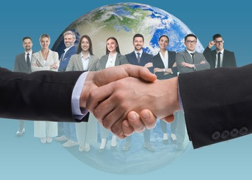 Image of Partners shaking hands against group of business people and globe