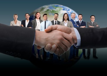 Image of Partners shaking hands against group of business people and globe