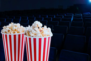 Image of Buckets of fresh popcorn and seats in dark cinema