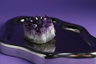 Photo of Beautiful amethyst gemstone on purple background, closeup