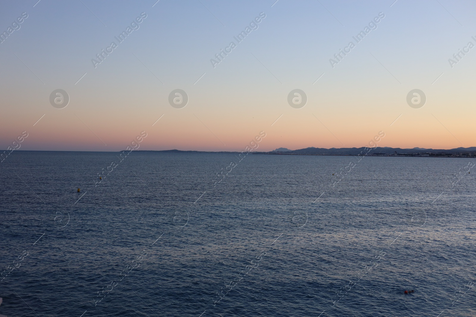 Photo of Beautiful seascape with city and mountains at sunset