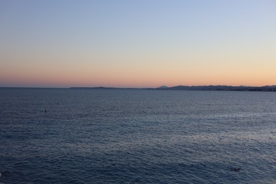 Photo of Beautiful seascape with city and mountains at sunset