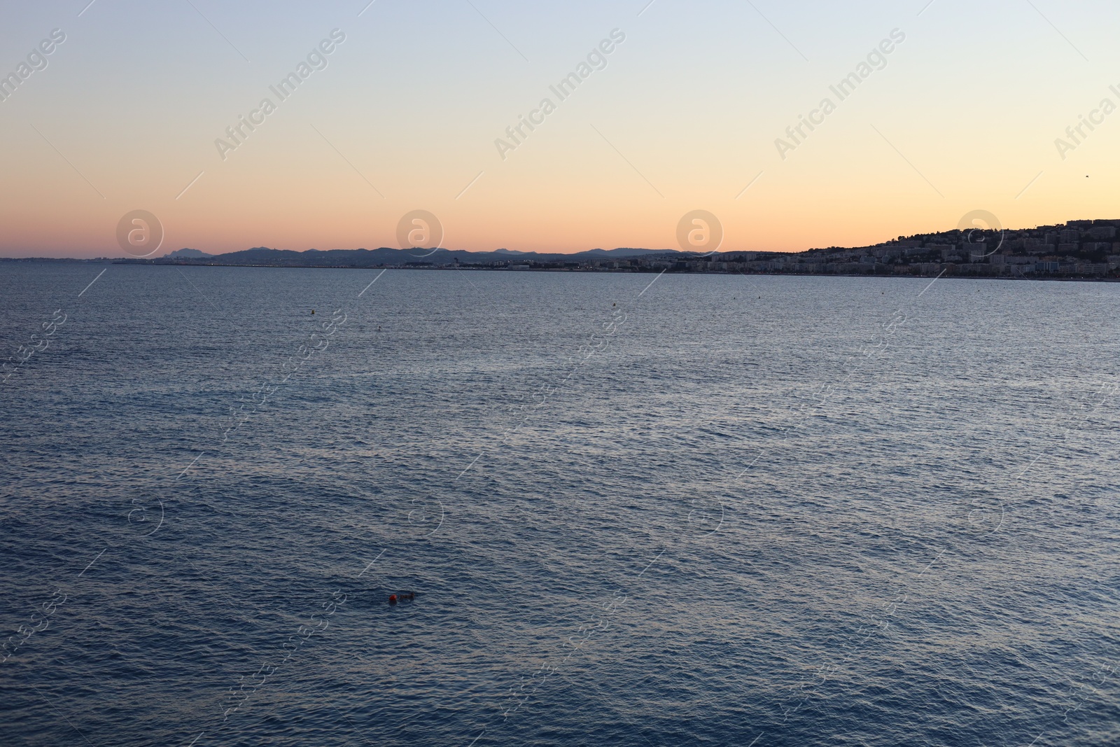 Photo of Beautiful seascape with city and mountains at sunset