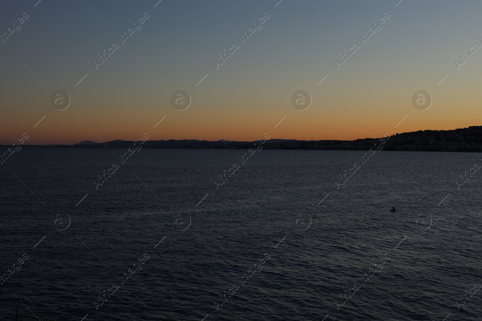 Photo of Beautiful seascape with city and mountains at sunset