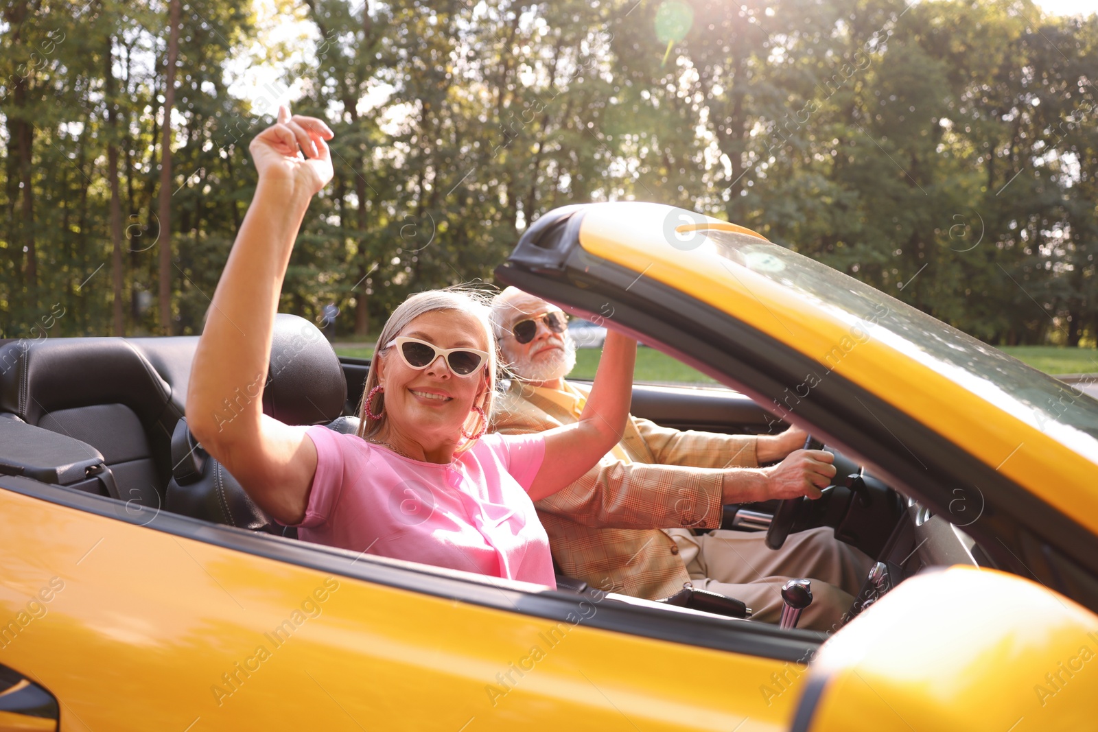 Photo of Senior couple enjoying cabriolet ride in city, selective focus