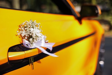 Photo of Wedding car. Cabriolet decorated with beautiful flowers outdoors, closeup
