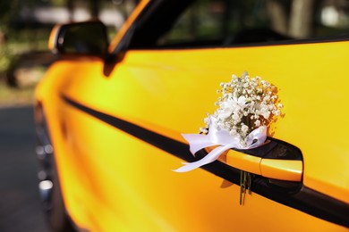 Photo of Wedding car. Cabriolet decorated with beautiful flowers outdoors, closeup