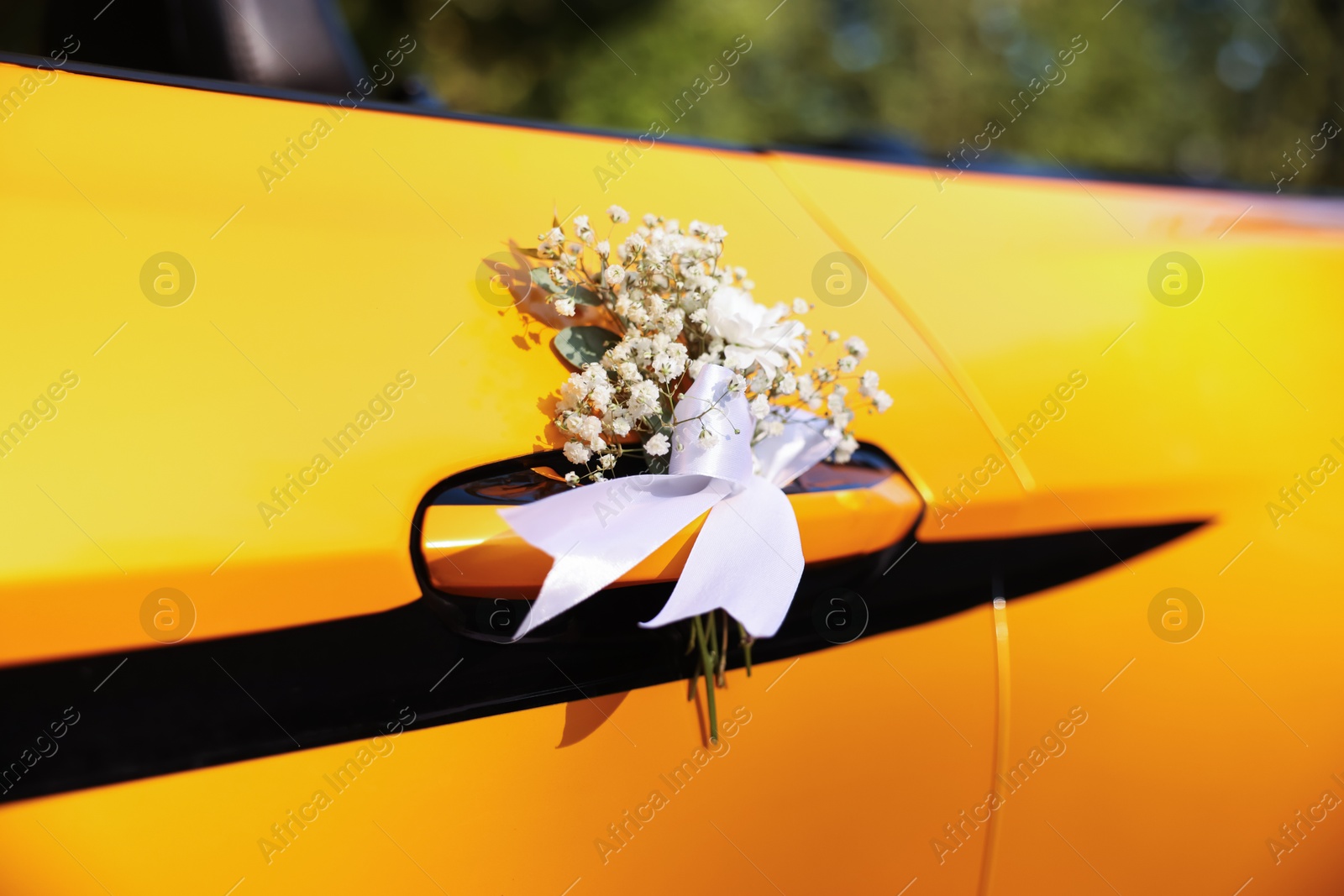 Photo of Wedding car. Cabriolet decorated with beautiful flowers outdoors, closeup