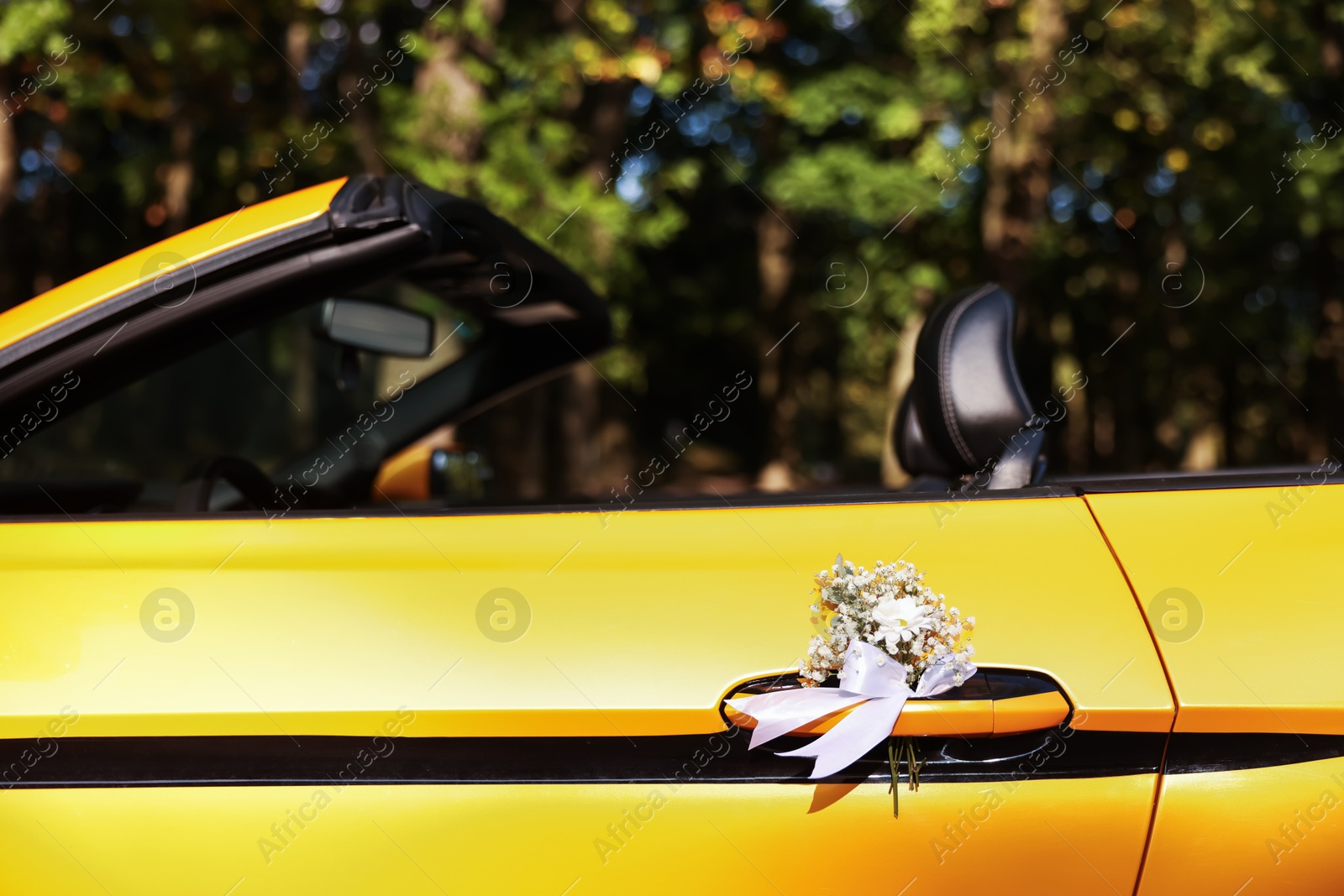 Photo of Wedding car. Cabriolet decorated with beautiful flowers outdoors, closeup
