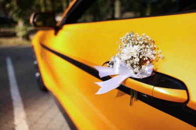 Photo of Wedding car. Cabriolet decorated with beautiful flowers outdoors, closeup