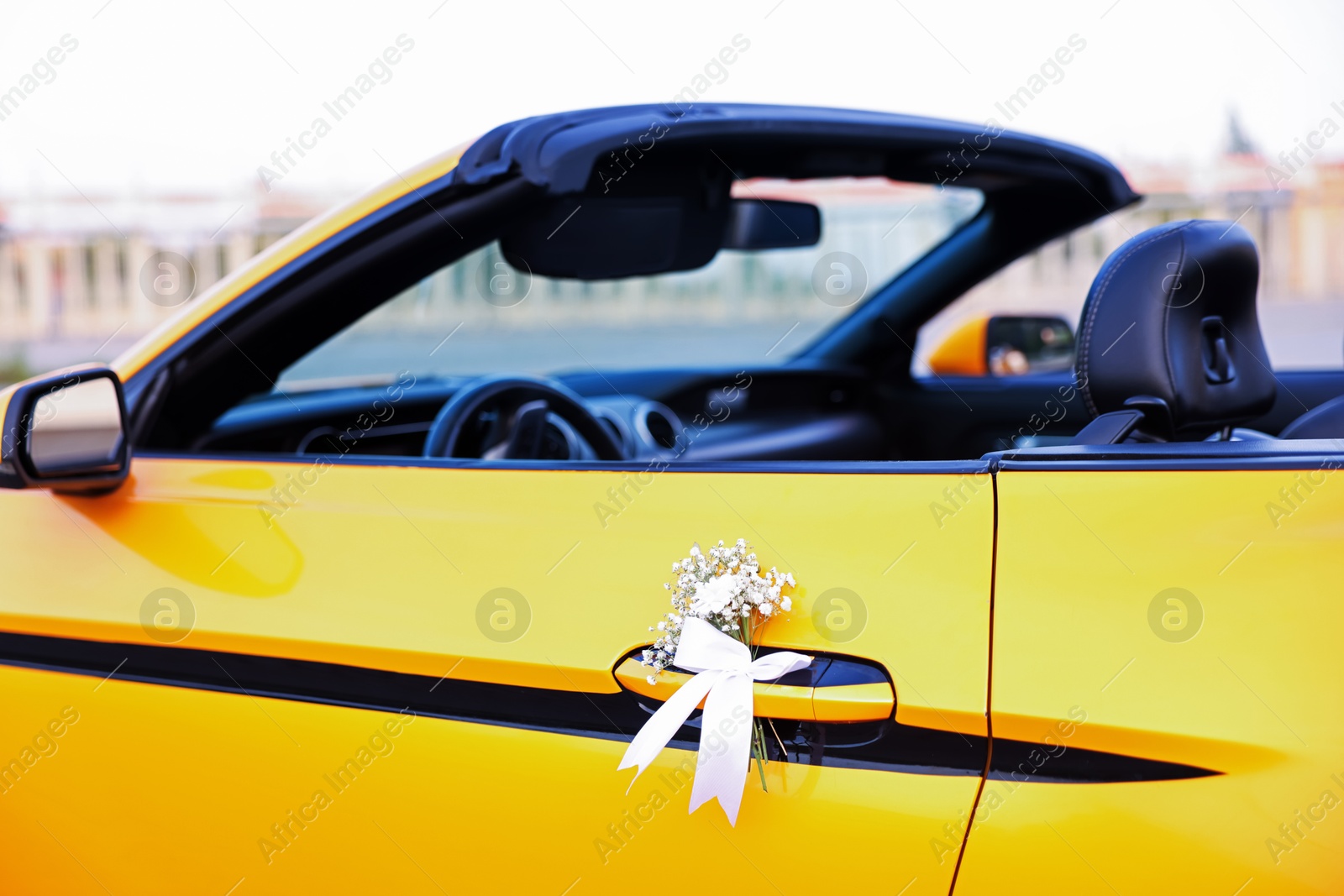 Photo of Wedding car. Cabriolet decorated with beautiful flowers outdoors, closeup