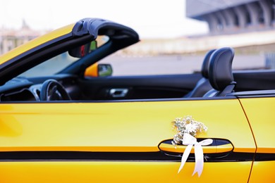 Photo of Wedding car. Cabriolet decorated with beautiful flowers outdoors, closeup