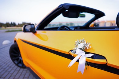 Photo of Wedding car. Cabriolet decorated with beautiful flowers outdoors, closeup