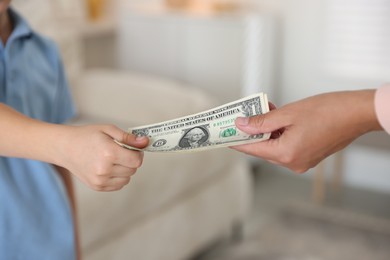 Photo of Mother giving pocket money to her son at home, closeup