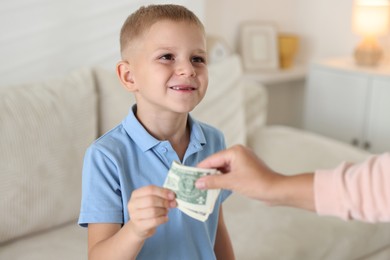 Photo of Mother giving pocket money to her son at home, closeup