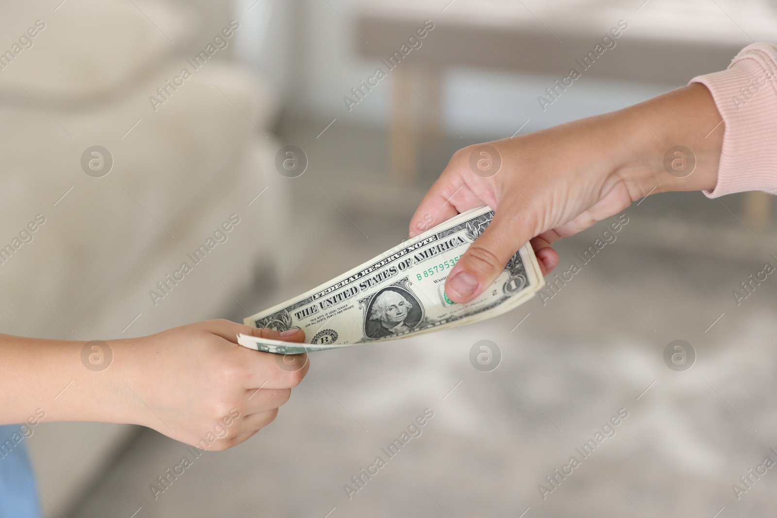Photo of Mother giving pocket money to her son at home, closeup