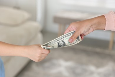 Photo of Mother giving pocket money to her son at home, closeup