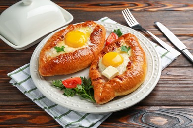 Photo of Tasty khachapuri with cheese and eggs served on wooden table