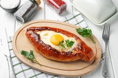 Photo of Tasty khachapuri with cheese and egg served on white wooden table, above view