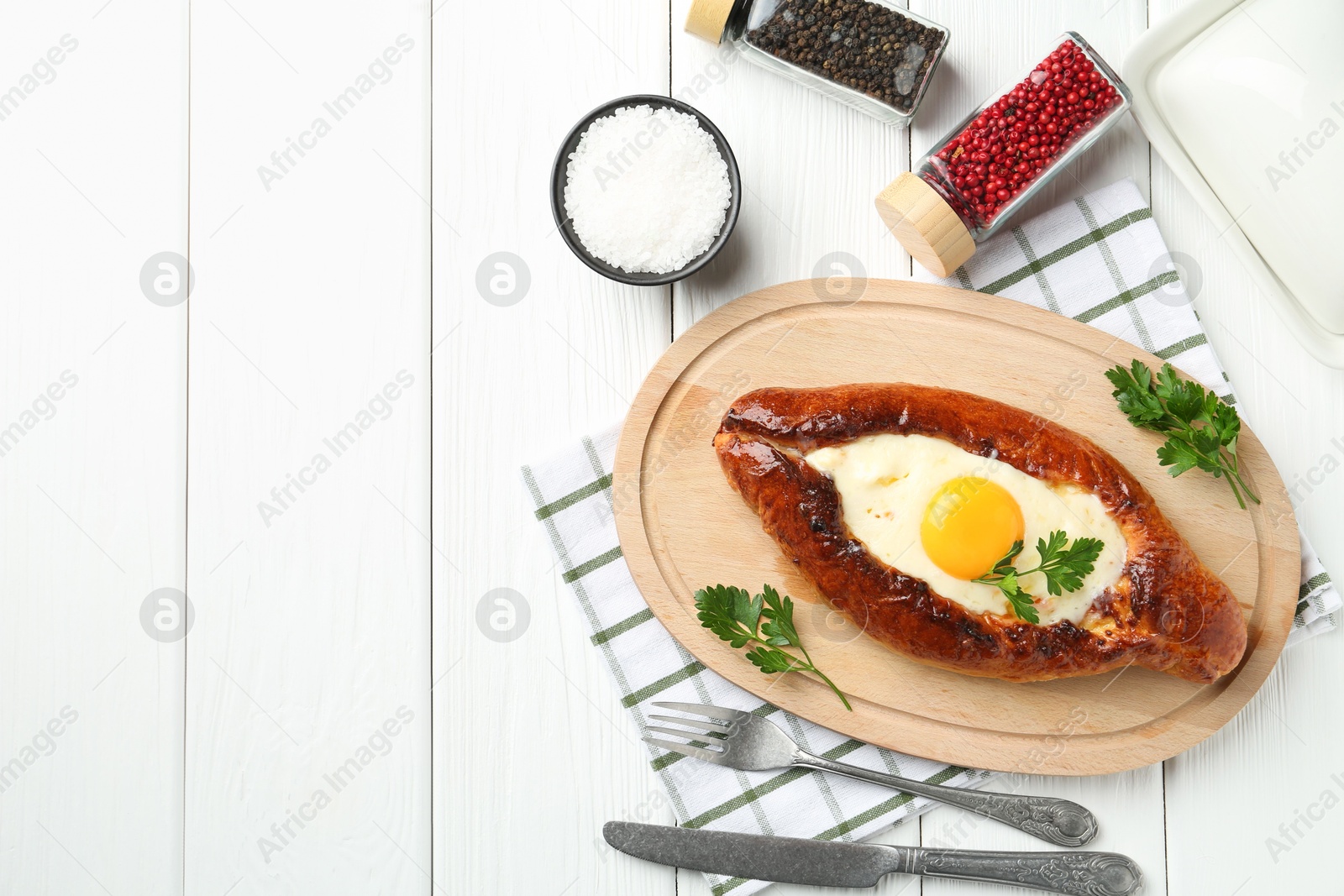 Photo of Tasty khachapuri with cheese and egg served on white wooden table, flat lay. Space for text