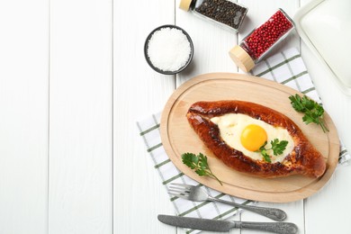 Photo of Tasty khachapuri with cheese and egg served on white wooden table, flat lay. Space for text