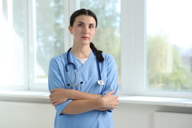 Photo of Nurse with stethoscope near window in clinic