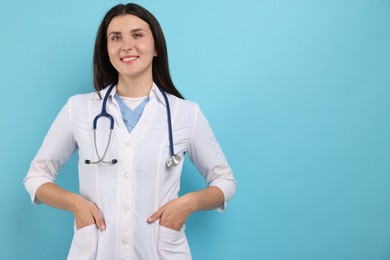 Photo of Portrait of nurse with stethoscope on light blue background, space for text