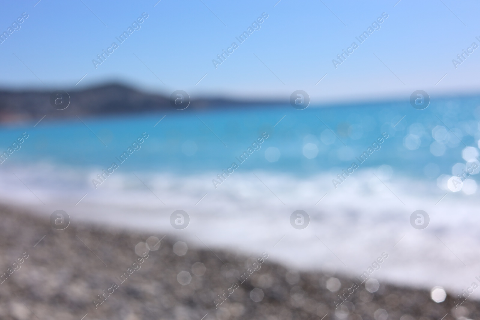 Photo of Blurred view of wavy sea and pebbles on beach