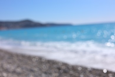 Photo of Blurred view of wavy sea and pebbles on beach