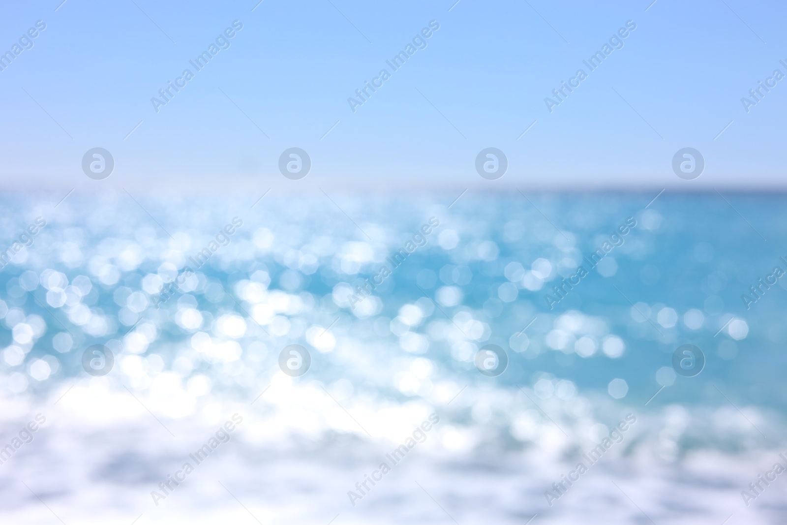 Photo of Blurred view of wavy sea and blue sky on sunny day