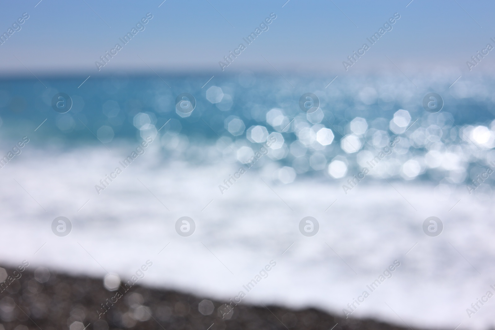 Photo of Blurred view of wavy sea and pebbles on beach