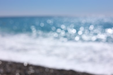 Photo of Blurred view of wavy sea and pebbles on beach