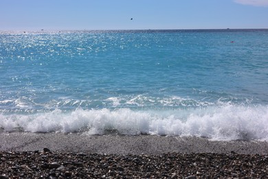 Photo of Beautiful view of wavy sea and pebbles on beach